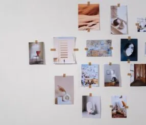 Como decorar a casa para ficar com a minha cara sem gastar muito Colagem de várias fotografias destacadas em uma parede clara, com fita adesiva.